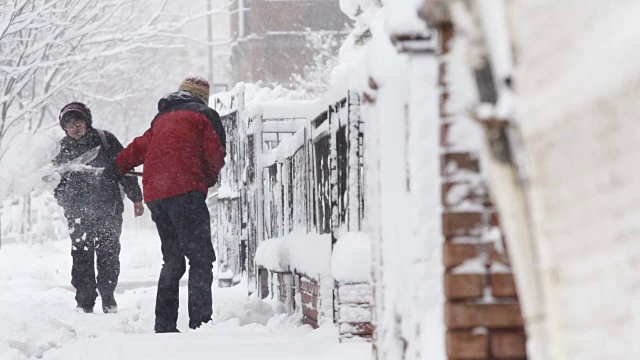 在纽约布鲁克林的一场暴风雪中，一个面目全非的男子在铲雪——慢动作视频素材