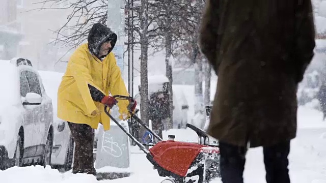 在纽约布鲁克林，一名坦率的、面目全非的男子在暴风雪中铲雪视频素材