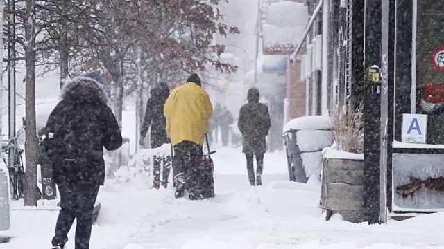 2017年冬天的暴风雪中，一群不认识的、直率的人走在下雪的纽约街道上视频素材