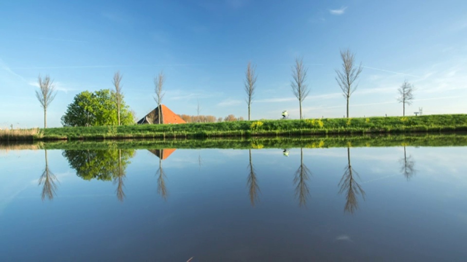 荷兰，Zuidoostbeemster，比姆斯特围场附近的农场，比姆斯特围场是联合国教科文组织世界遗产。骑自行车的人视频素材