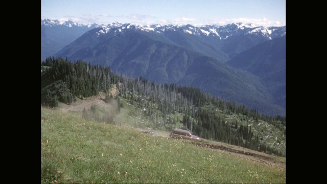 WS汽车在土路上移动，背景是积雪覆盖的山脉/华盛顿州，美国视频素材