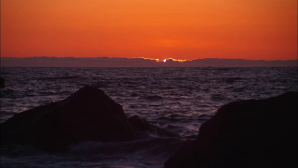 橙色天空下，海浪拍打着夏威夷海岸。视频素材