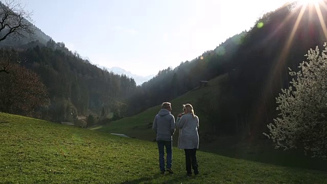 夫妇走过山草地，日出视频素材