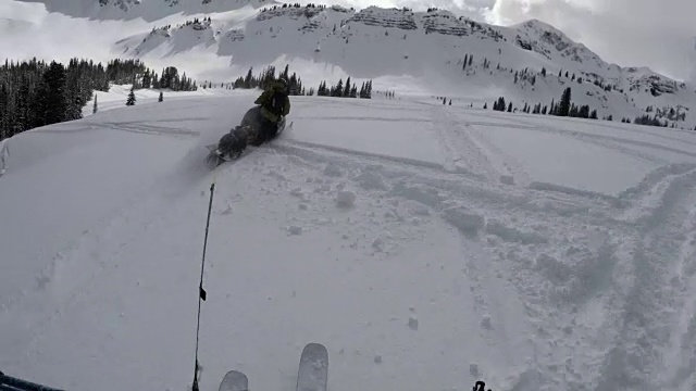 外面很冷——在落基山脉的边远地区，一个认不出的真实的人被一辆雪地摩托拖着走——4k视频素材