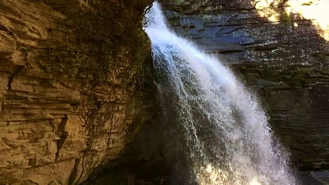 一个巨大和嘈杂的瀑布滴水在一个令人惊叹的场景在雨季在加泰罗尼亚地区的科尔萨卡布拉山靠近巴塞罗那与洞和自然拱门在一个美丽的角落。视频素材