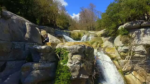 在加泰罗尼亚地区的科尔萨卡布拉山脉，一名敢于冒险的男子在雨季的时候在一个瀑布的顶部自拍，这个瀑布有着丰富的水和数百米的落差，有着令人惊叹的风景。视频素材