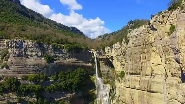 在加泰罗尼亚地区的科尔萨卡布拉山脉的雨季，无人机拍摄了一个令人惊叹的百米瀑布和漂亮的悬崖。视频素材