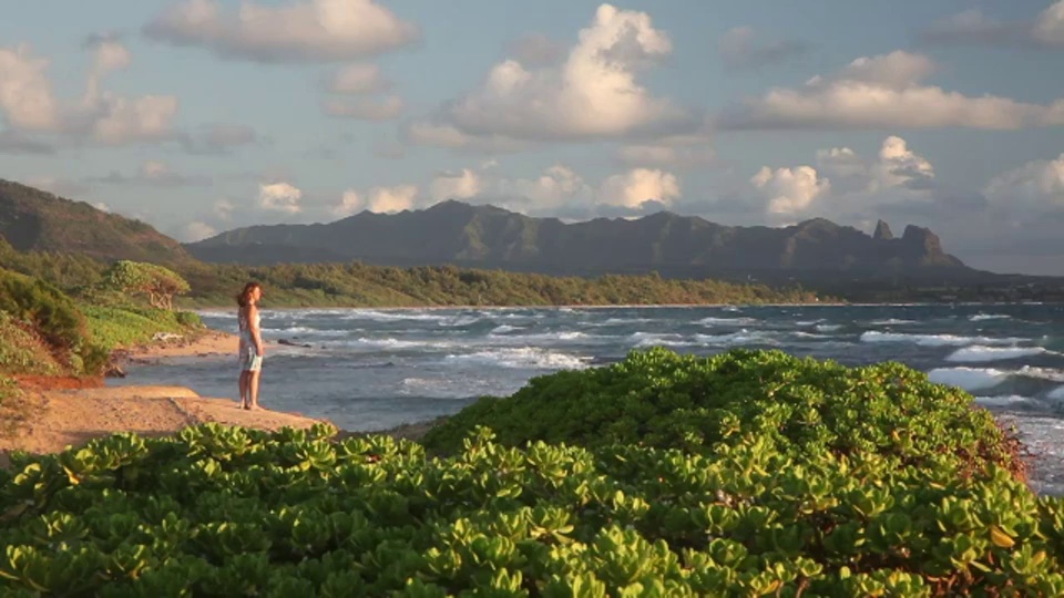 在夏威夷的利休，一名妇女在Nukoli'i海滩上凝视着太平洋海浪。视频下载