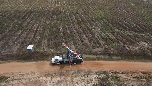 在一架直升机后面的塔克-无人机空中4K空中拍摄特技直升机喷洒农药和杀虫剂的作物和树木为生产各种需要4K运输的农业视频素材