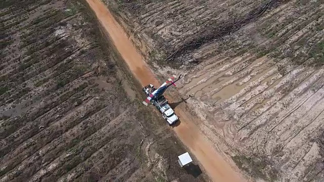 高空俯瞰直升机降落在卡车上无人机空中4K空中拍摄特技直升机向农作物和树木喷洒农药和杀虫剂，用于生产各种需要4K的农业运输视频素材