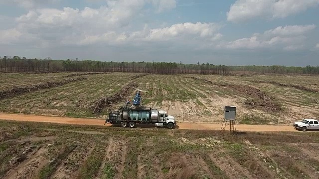 前方直升机起飞和跟随-无人机空中4K空中拍摄特技直升机喷洒农药和杀虫剂到农作物和树木上，用于生产各种需要4K的农业运输视频素材