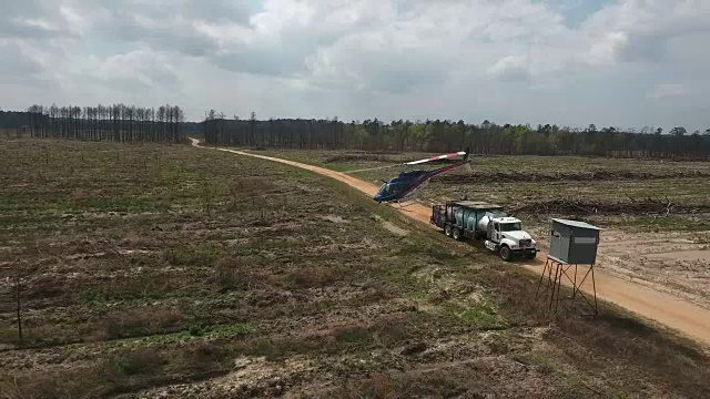 直升机起飞侧面跟踪和跟随-无人机空中4K空中拍摄特技直升机喷洒农药和杀虫剂在作物和树木上生产各种需要4K运输视频素材