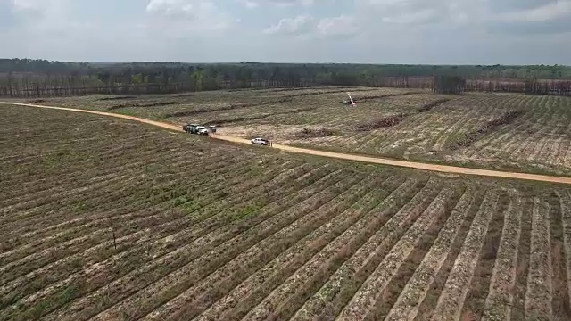 跟踪一架直升机在卡车上着陆-无人机空中4K空中拍摄特技直升机喷洒农药和杀虫剂在作物和树木上生产各种需要4K运输视频素材