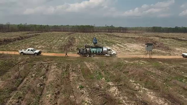 跟踪一架直升机来着陆-无人机空中4K空中拍摄特技直升机喷洒农药和杀虫剂在作物和树木上生产的各种农业需要4K运输视频素材