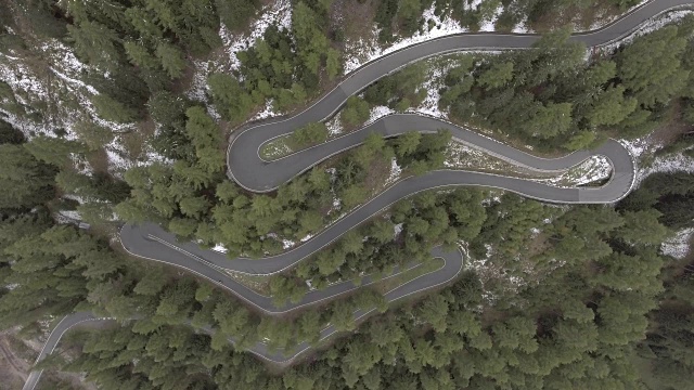 鸟瞰图的摩托车在蜿蜒的道路中树木在冬天，伞形通道，瑞士视频素材