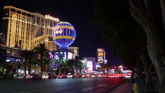 美国内华达州拉斯维加斯，人们在夜晚看着喷泉和街道上的交通，背景是酒店建筑视频素材