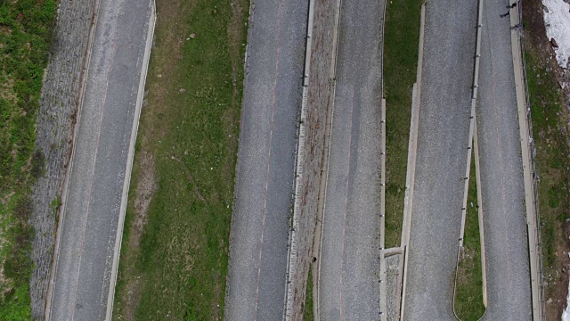 鸟瞰图，行人和摩托车行驶在蜿蜒的道路上，瑞士特雷莫拉路视频素材