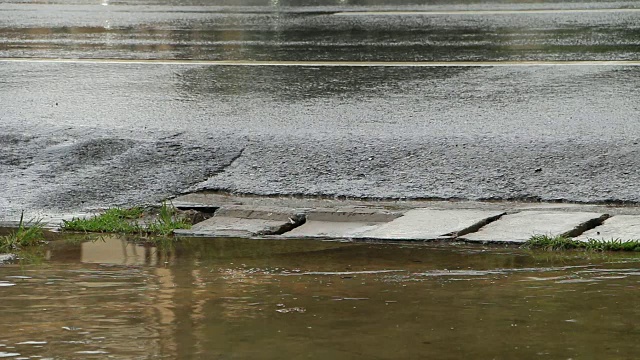 雨点溅落在柏油路上。视频素材