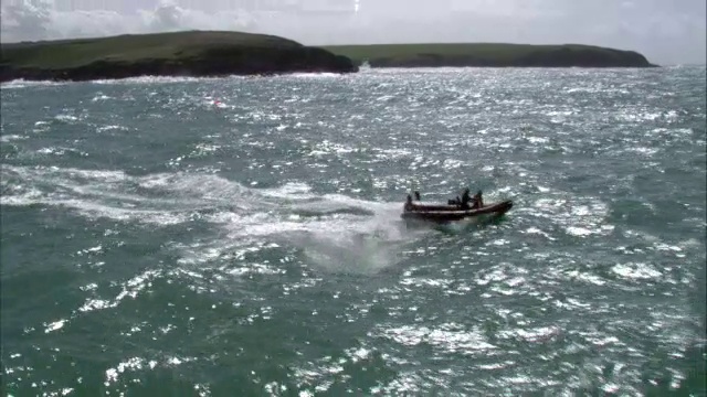 在英国康沃尔附近海岸的充气肋骨船上空飞行视频素材