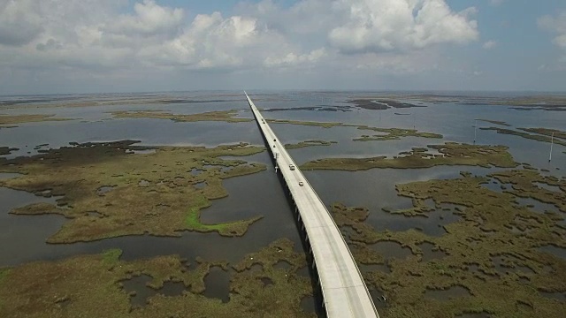 侧飞向前无限桥-无人机无人机4K湖Pontchartrain堤道格兰德岛路易斯安那海岸密西西比河大桥和驳船沼泽地，海湾三角洲，野生动物4K运输视频素材