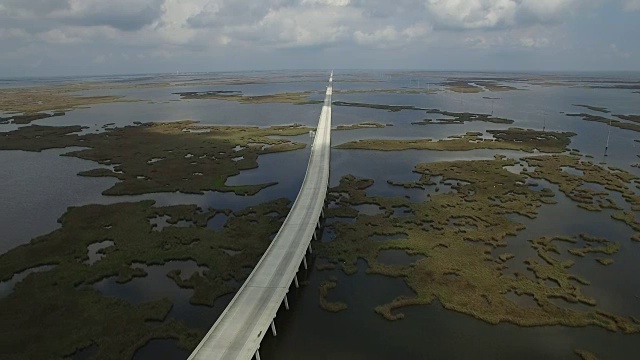 旁跟踪桥堤-无人机无人机4K湖Pontchartrain堤道格兰德岛路易斯安那海岸密西西比河大桥和驳船沼泽地，海湾三角洲，野生动物4K运输视频素材