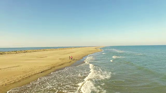 在加泰罗尼亚地区旅行的周末，一对直男情侣在地中海和低浪的埃布罗三角洲海滩上散步，用无人机拍摄了这段视频。4 k UHD。视频素材