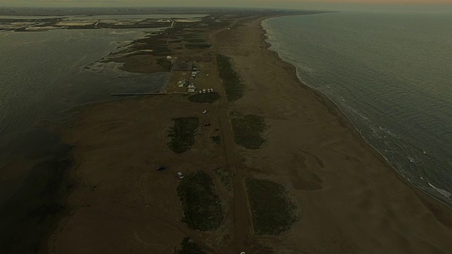 在日落时分，无人机在加泰罗尼亚地区的海滩和平坦的风景中，飞越埃布罗三角洲之间那片令人惊叹的狭长土地。4 k UHD。视频素材