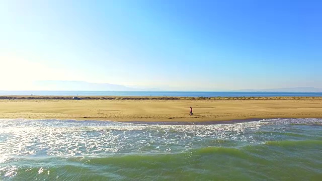 在加泰罗尼亚地区旅行的周末，一对直男情侣在地中海和低浪的埃布罗三角洲海滩上散步，用无人机拍摄了这段视频。4 k UHD。视频素材