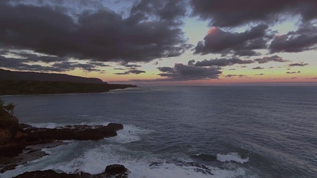 天线。日落时分，镜头在太平洋上空盘旋，海浪撞击着岩石嶙峋的岛屿海岸。视频素材