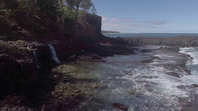 天线。两个瀑布从山间溪流溢出到夏威夷岛屿的海边。视频素材