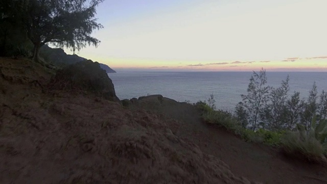 天线。日落时分，镜头从风景秀丽的夏威夷山间飞过太平洋。视频素材