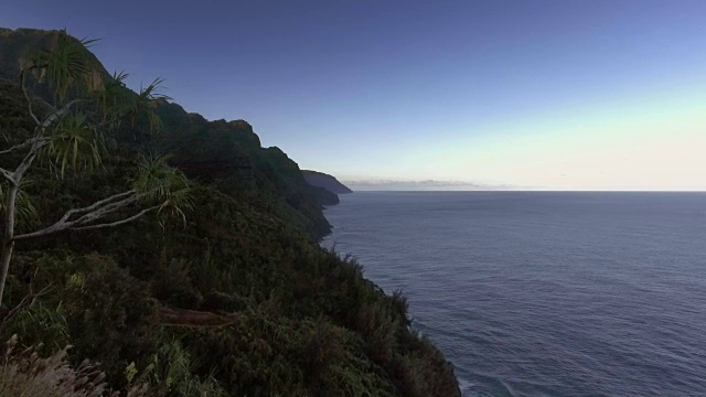 天线。镜头从森林覆盖的山坡飞向美丽的岛屿海岸线。视频素材