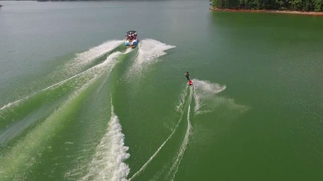 4k Wakeboard, wake surfing and wake skating on georgia lake on beautiful water extreme action sports, front flip, backflip, twist and wipeout tracking揭示4k运动视频素材