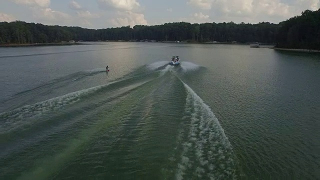 滑水板，wake surfing和wake skating在乔治亚湖上美丽的水上极限动作运动，前空翻，后空翻，扭转和清除跟踪揭示4k运动视频素材