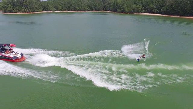 无人机航拍视频4k Wakeboard, wake surfing和wake skating on georgia lake on beautiful water extreme action sports, front flip, backflip, twist和wipeout tracking reveal 4k sports视频素材