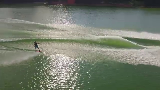 侧盘wake board做技巧-无人机航拍视频4k Wakeboard, wake surfing和wake skating在美丽的水极限运动乔治亚湖，前翻，后翻，扭转和擦除跟踪揭示4k运动视频素材