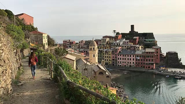 一个女孩漫步在蓝色的小路上，俯瞰着Vernazza。五渔村视频素材