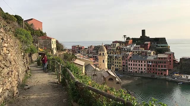 一个女孩漫步在蓝色的小路上，俯瞰着Vernazza。五渔村视频素材