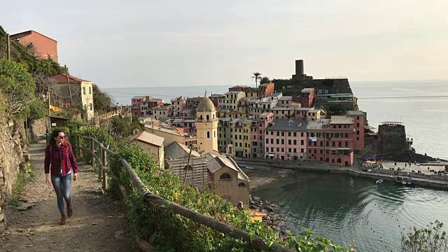 一个女孩漫步在蓝色的小路上，俯瞰着Vernazza。五渔村视频素材