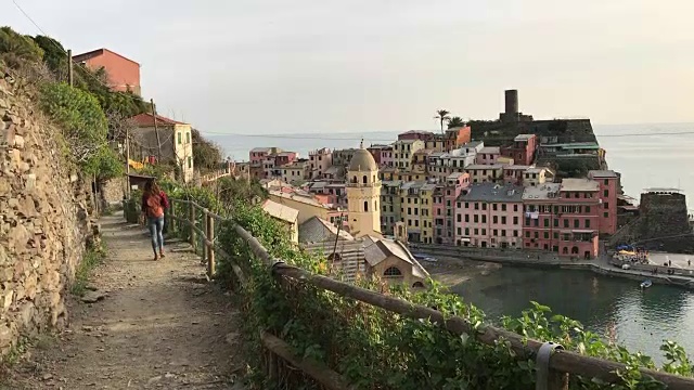 一个女孩漫步在蓝色的小路上，俯瞰着Vernazza。五渔村视频素材