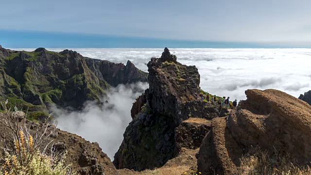 徒步旅行者到达云层之上的山峰视频下载