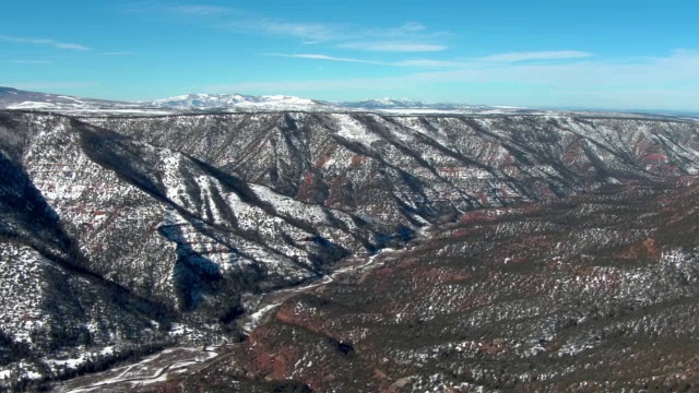 蓝天下，雪堆在山坡上。视频素材