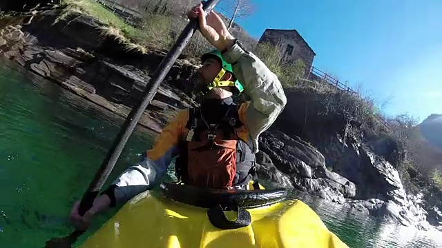 皮划艇在高山河流上划桨穿过峡谷视频素材