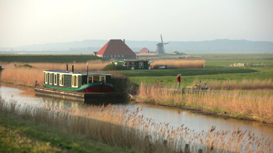 荷兰，Petten, Polder叫做petemer Polder。船屋，船，农场，风车。女人的周期视频素材