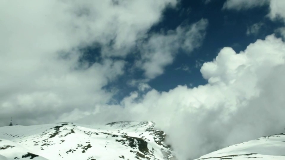 乌云在白雪皑皑的山峰上翻滚。视频素材