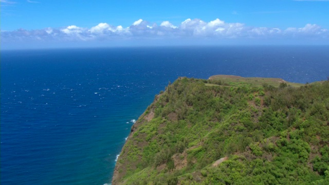 一个陡峭，郁郁葱葱的悬崖俯瞰太平洋在毛伊岛生动的蓝色海水。视频素材