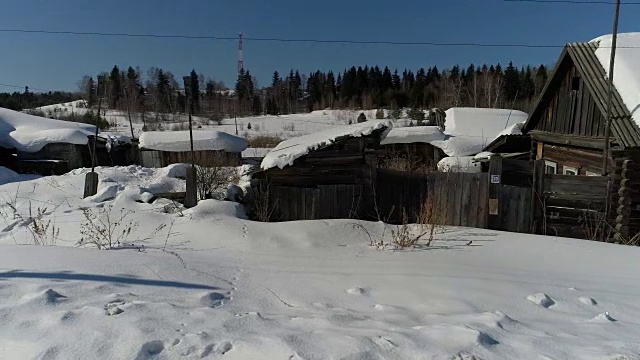 一个典型的西伯利亚村庄。冬天。房顶上有很多雪。传统的俄罗斯木屋是小屋。视频素材