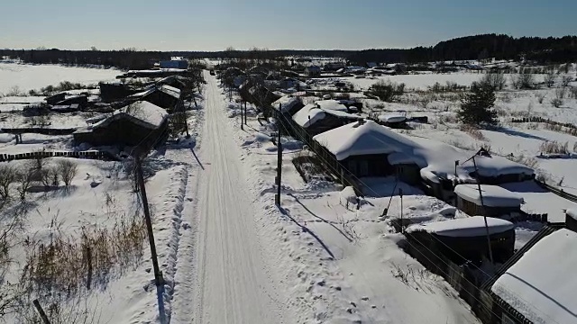 一个典型的西伯利亚村庄。冬天。房顶上有很多雪。传统的俄罗斯木屋是小屋。视频素材