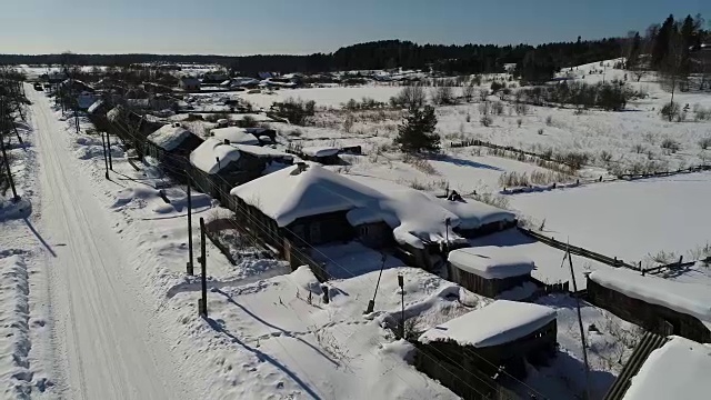 一个典型的西伯利亚村庄。冬天。房顶上有很多雪。传统的俄罗斯木屋是小屋。视频素材