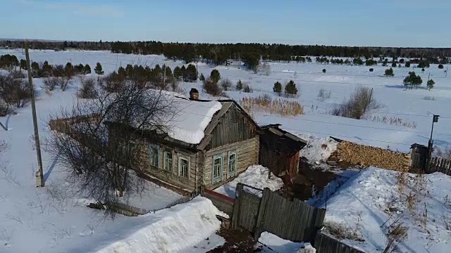 一个典型的西伯利亚村庄。冬天。房顶上有很多雪。传统的俄罗斯木屋是小屋。视频素材